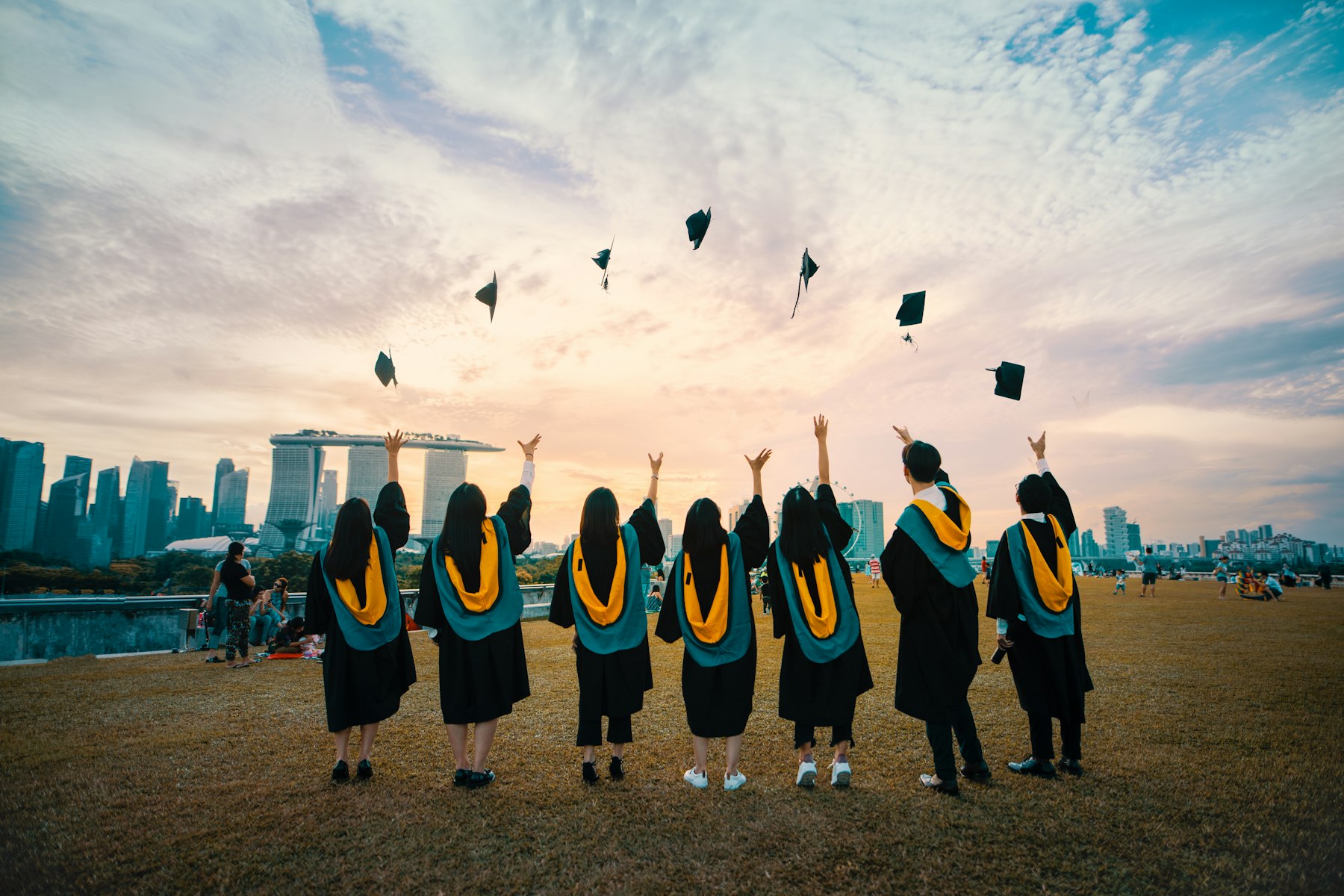 Graduates in gowns celebrating in front of a university building