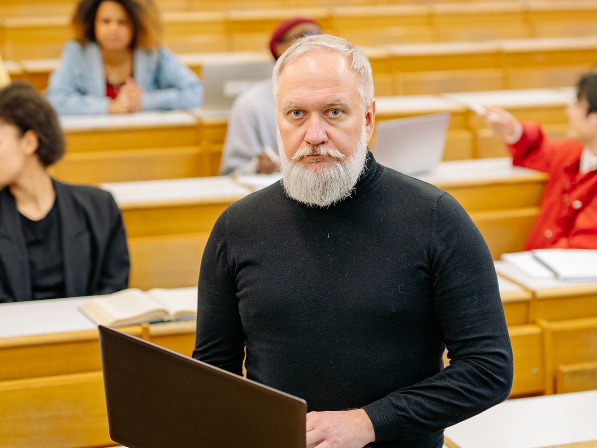 Senior professor with a laptop in a university lecture theatre