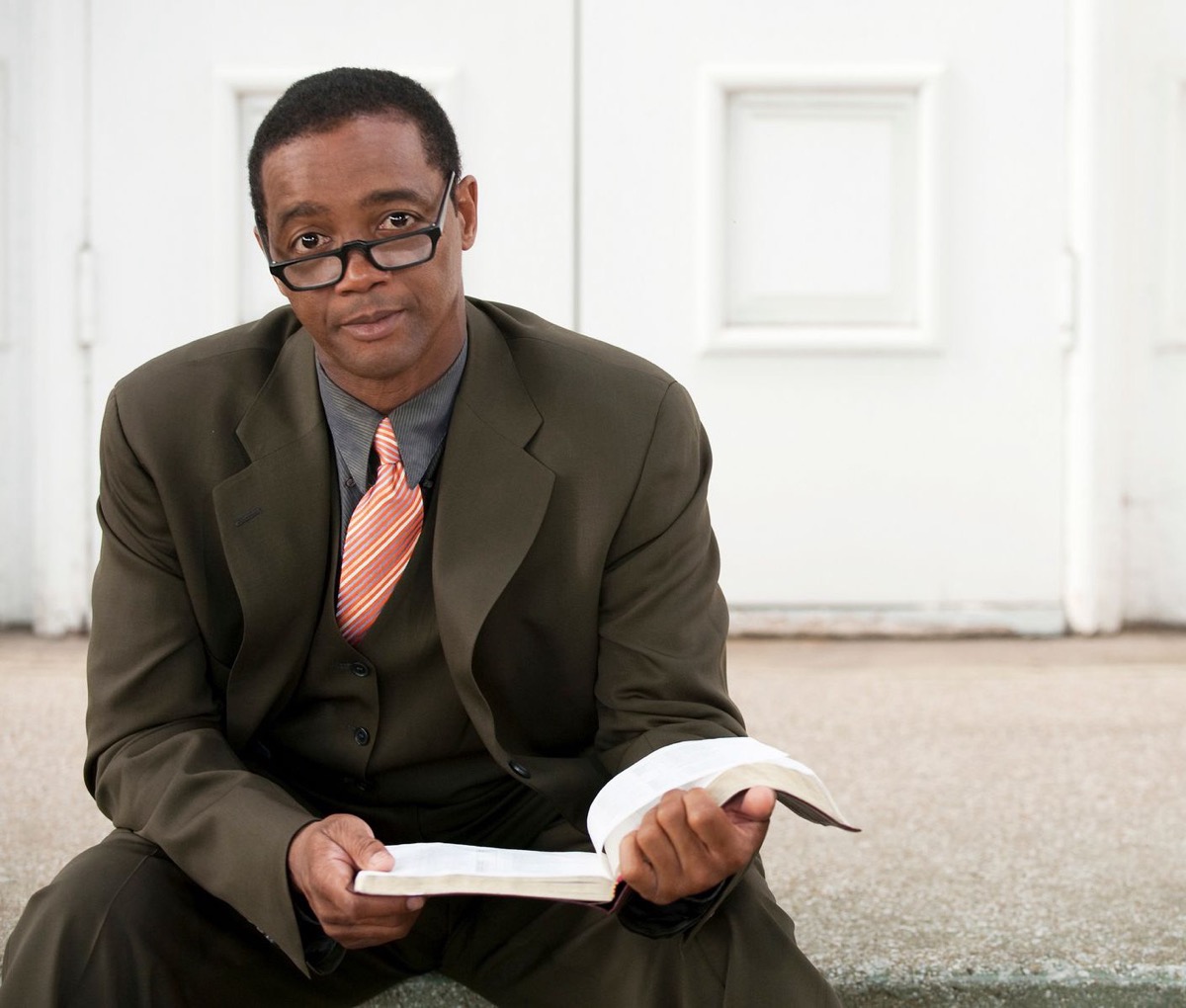 Experienced educator with an open book, glasses in hand